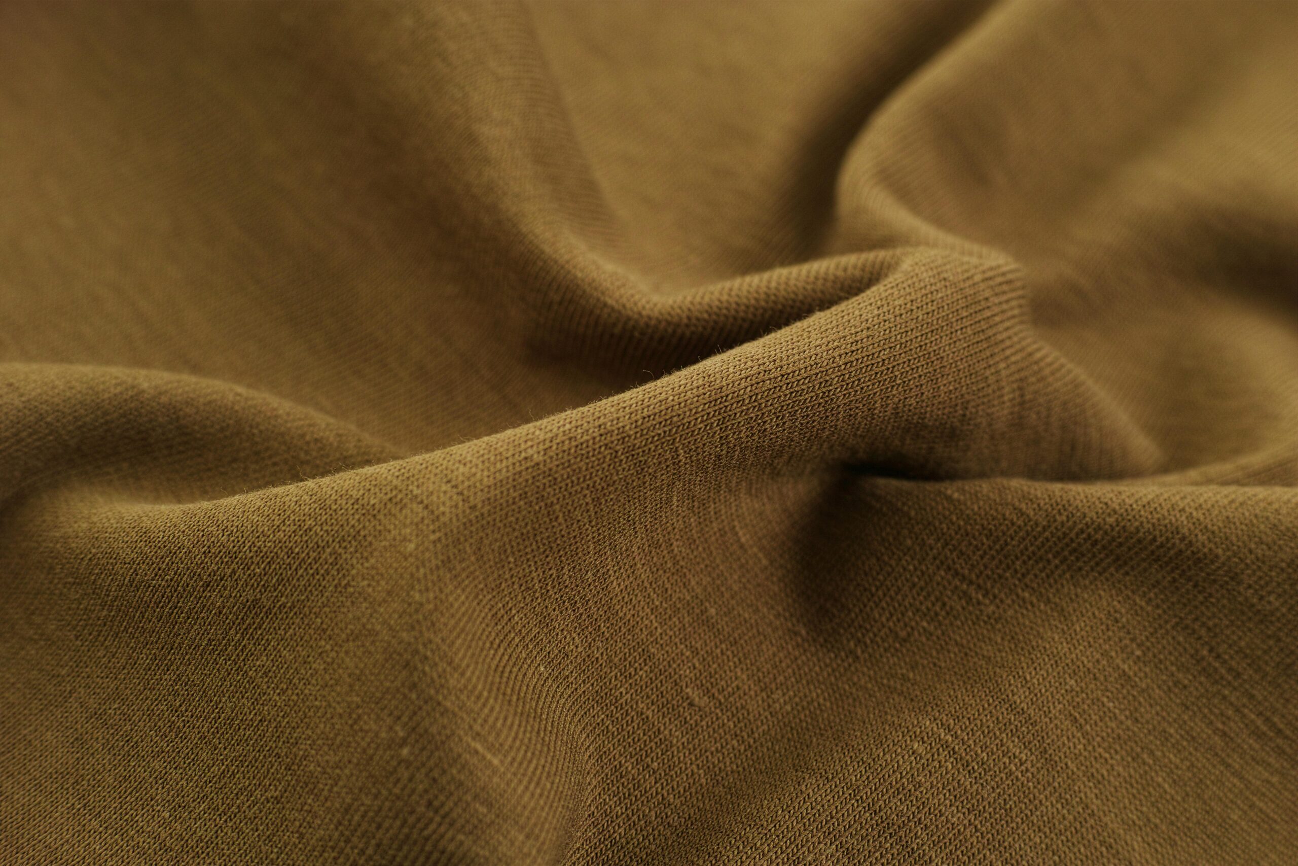 Detailed close-up view of brown fabric with visible folds, creases, and texture.